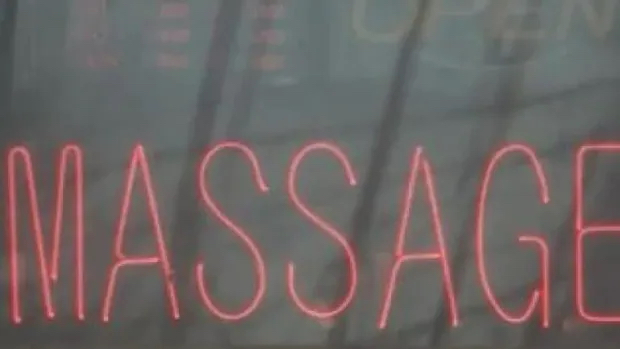 A sign advertises the services of a massage parlour. Those businesses are currently shuttered by the pandemic...