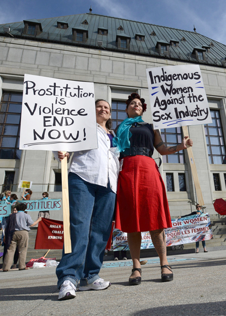 Cherry Smiley, middle right, of Vancouver, B.C., and Sue Martin, left, of Ottawa join others as they rally in front the Supreme Court of Canada in Ottawa on Thursday, June 13, 2013. The SCOC is hearing arguments on the constitutionality of Canada's prostitution laws. PHOTO: SEAN KILPATRICK/THE CANADIAN PRESS