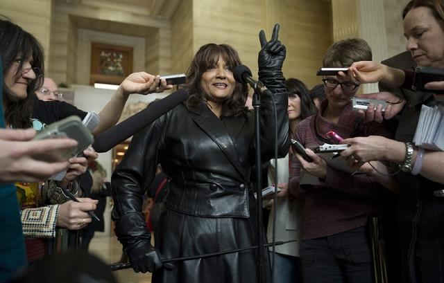 Terri-Jean Bedford flashes a victory sign as she speaks with the media after learning Canada's highest court struck down the country's prostitution laws at the Supreme Court of Canada in Ottawa Friday December 20, 2013. Photo: Adrian Wyld, Canadian Press