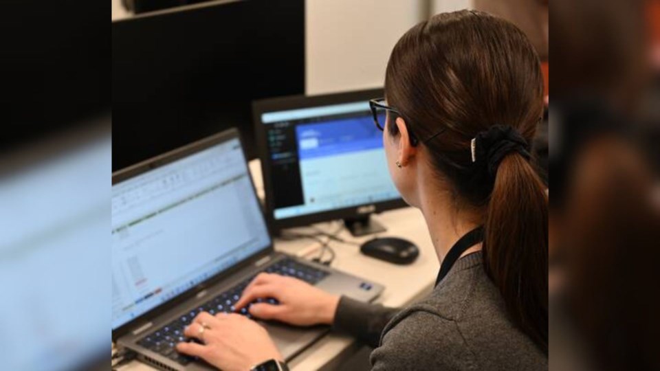 An RCMP analyst works on her laptop researching people seeking sexual services from undercover officers. Photo courtesy of BC RCMP
