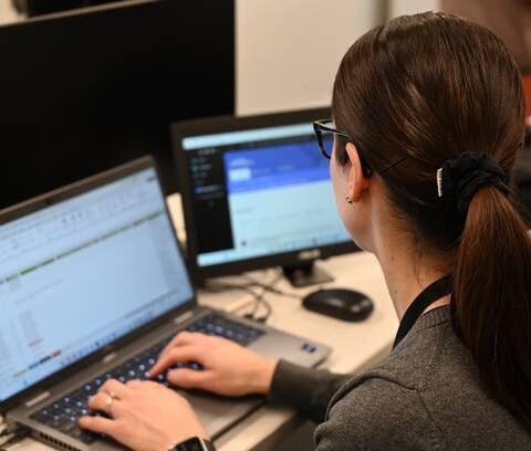 An RCMP analyst works on her laptop researching men seeking sexual services from undercover officers. Photo: RCMP